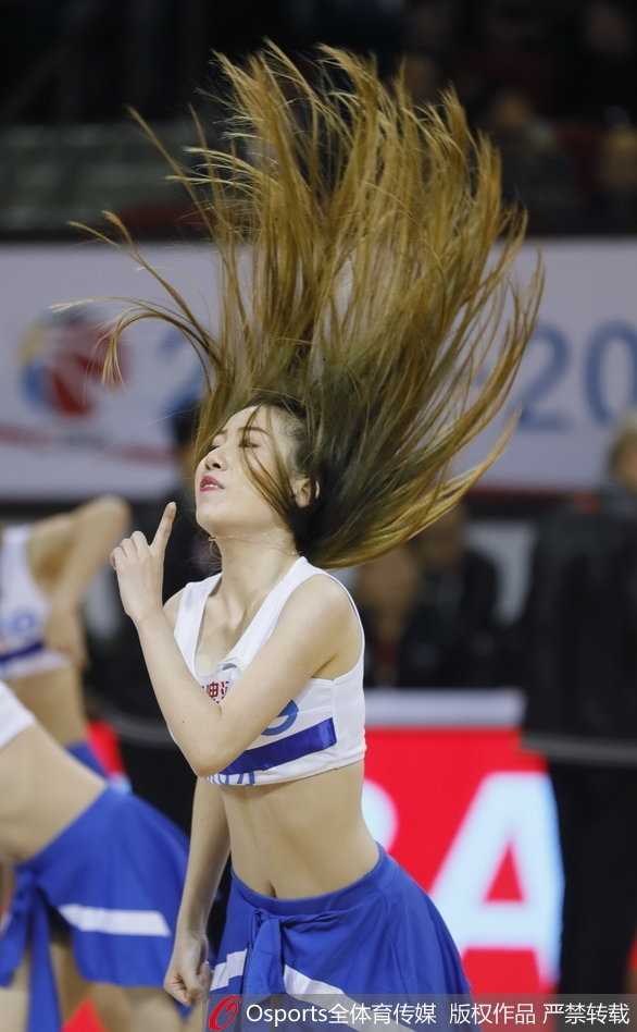 一位领舞的篮球宝贝眼神专注而自信，她侧身凝视，展现出完美的身体曲线和扎实的舞蹈功底，身后的队友们整齐列队，构成了赛前最令人期待的预热画面。