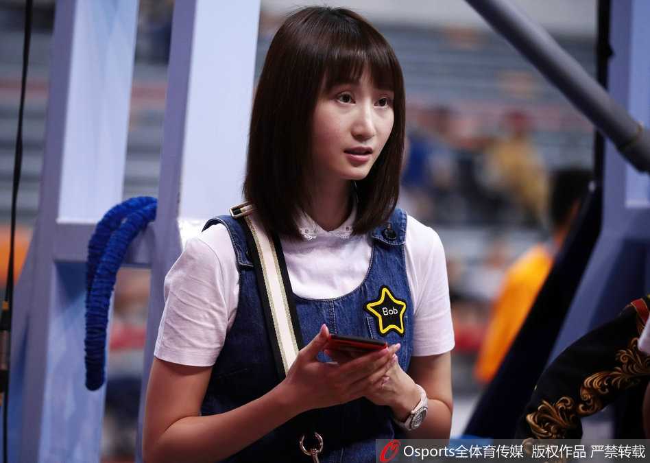 刘美不经意间的回眸，长发披肩，眼神清澈而坚定，牛仔短裙下的一双美腿在球场灯光下显得格外修长，成为场边一道流动的风景。