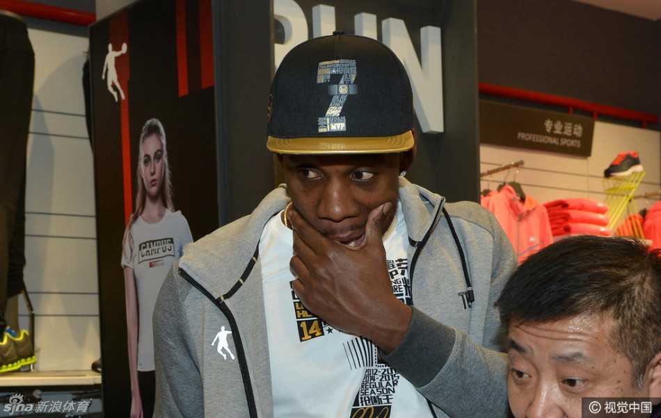 哈德森面带微笑为球迷签名，眼神中透露出对辽宁球迷多年支持的感激之情，现场气氛热烈而温馨