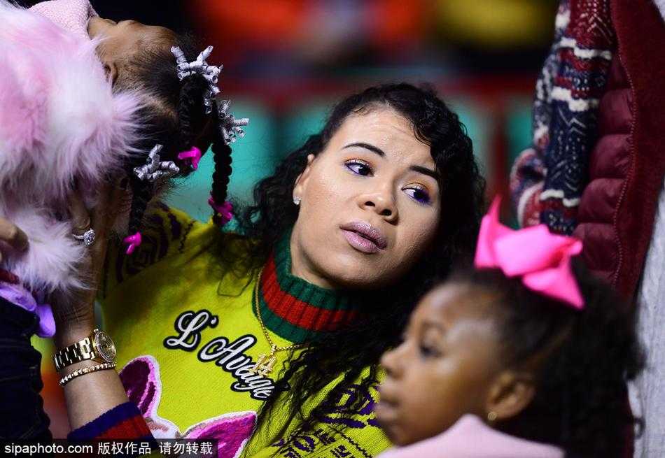 哈德森的小女儿在妈妈的怀抱中，好奇地望着球场上的爸爸，萌萌的表情惹人喜爱。