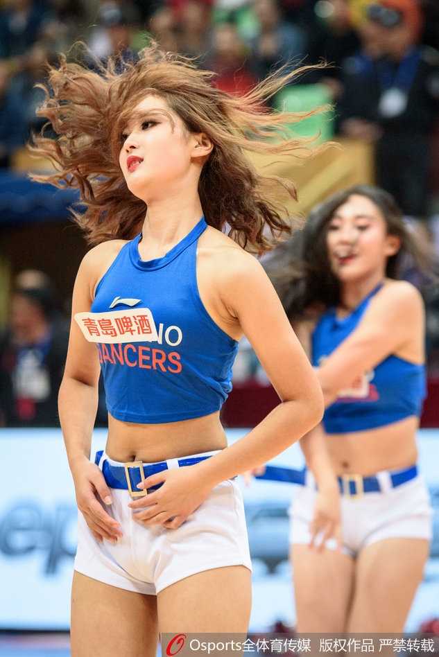 多名篮球宝贝在球场上排成整齐的队形，她们身着亮丽的队服，随着音乐的节拍舞动，动感十足的画面让人感受到青春的蓬勃朝气