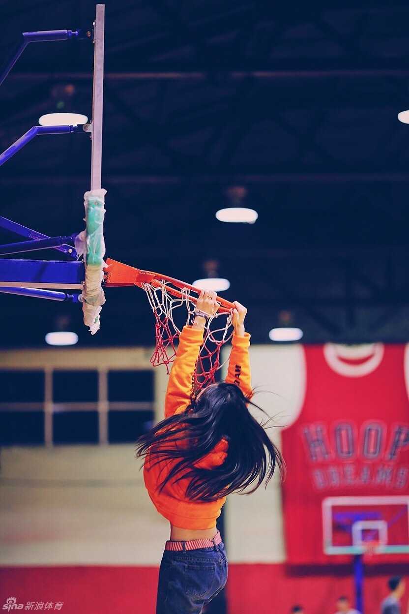 篮球在空中划过一道优美的弧线，空心穿过篮网，发出‘唰’的清脆声响。女孩保持着出手后的跟随动作，目光追随着篮球，脸上露出一丝满意的神情。