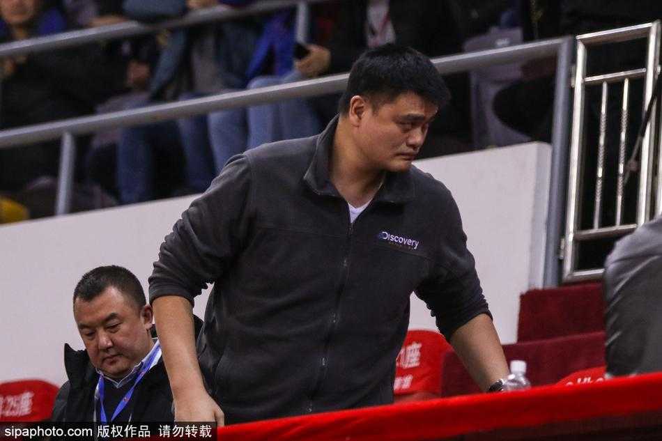 姚明与身旁的中国篮协工作人员低声交流，似乎在针对场上瞬息万变的局势交换意见，周围球迷的目光也被这位特殊的“督战官”所吸引。