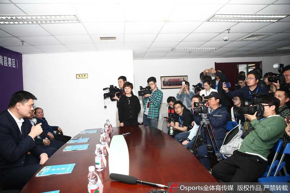 姚明在发布会现场倾听记者提问，由于身高出众，主办方特意为他准备了较高的立式麦克风，这一细节也凸显了他在中国篮球界鹤立鸡群的地位和影响力。