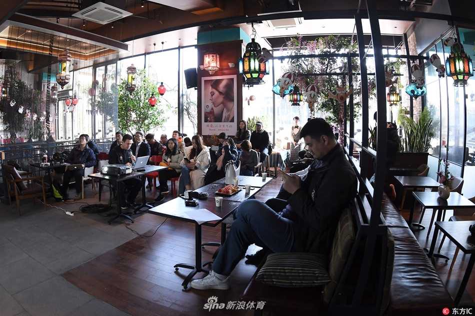 一张近景特写，姚明侧身看向镜头，身后是模糊的会议室背景，他眼神沉稳坚定，传递出面对挑战时的从容与担当。