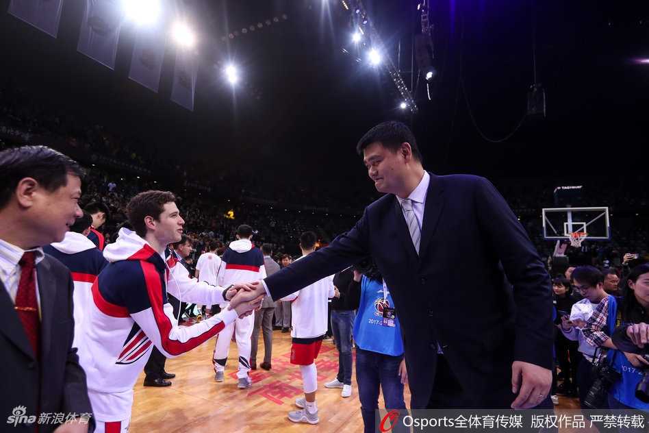 中国篮协主席姚明身着笔挺西装，在全明星颁奖典礼上，眼神中充满期许地望向手捧MVP奖杯的易建联，两代中国篮球领军人物的双手紧握在一起。