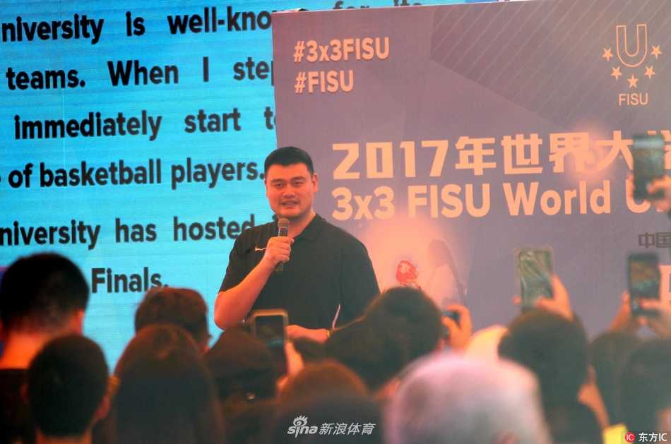 两名不同肤色的球员在篮下激烈拼抢篮板，一方高高跃起，手臂伸展到极限，另一方的防守动作也充满力量感，这正是世界大学生篮球交流的缩影。