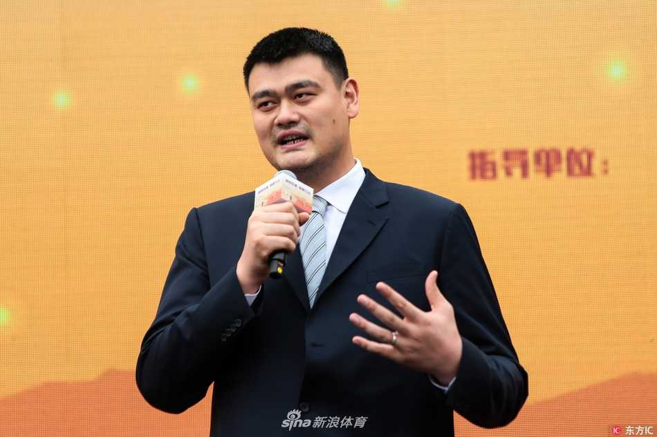 偌大的体育馆内，姚明站在台上，手拿话筒正在讲话，台下坐满了身穿校服的师生，大家的目光都聚焦在这位特殊的公益宣传大使身上，气氛庄重而热烈。