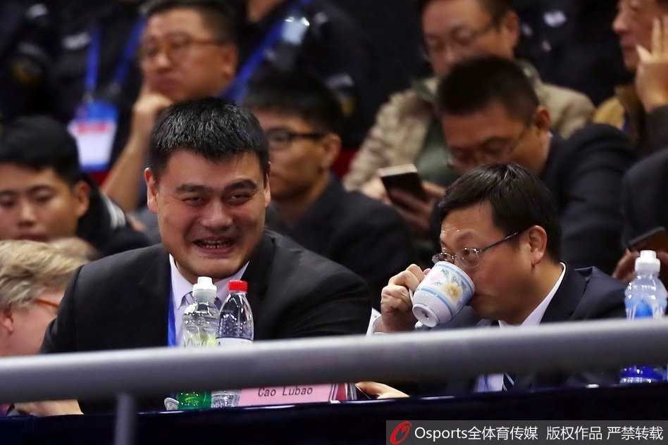 终场哨响后，姚明与主教练李楠在场边握手交谈，姚明微微低头倾听，眼神中既有对胜利的欣慰，也透露出对几天后客场恶战韩国队的深思与关切。