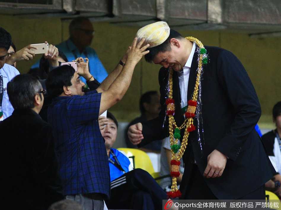 终场哨响，憾负的结果未能抹去赛场的温情。姚明在离场时被热情的印度当地球迷簇拥，一位身着传统服饰的观众向他赠送具有民族特色的服饰，姚明微笑接过，这一刻篮球超越了胜负，成为文化交流的桥梁。