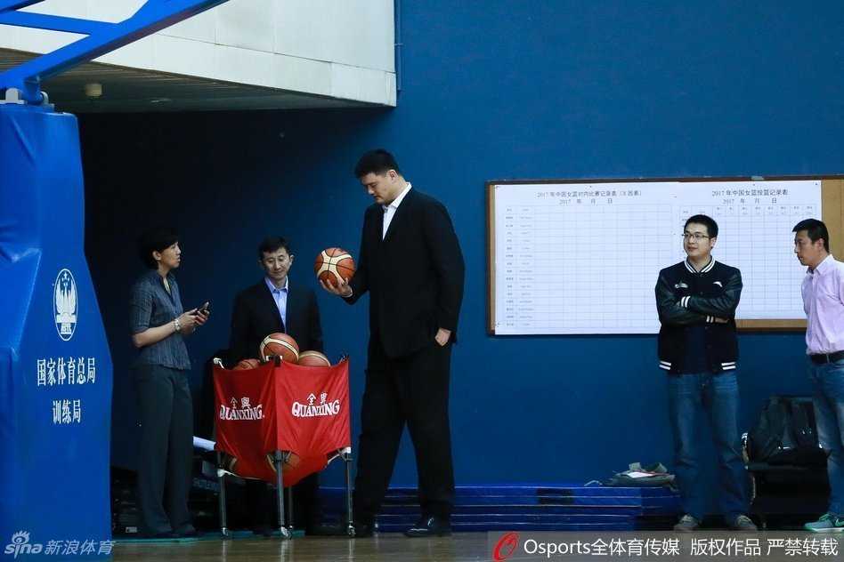 训练结束后，姚明走进场地中央对全队讲话，他高大的身躯微微前倾，神情诚恳而温和，队员们围成一个半圆仰望着他，画面充满了仪式感和传承的意味。