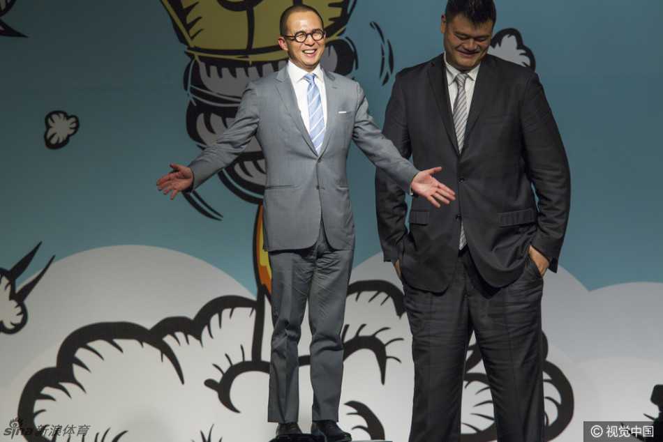 身形高大的姚明在人群中犹如灯塔，他微微侧身倾听霍启刚讲话，脸上带着标志性的幽默微笑，周围人的视线都不由自主地被这独特的风景线吸引。