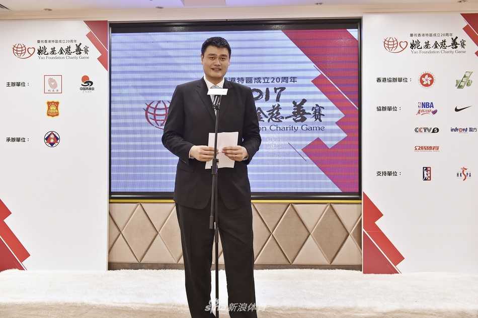 在活动现场的合影环节，姚明与众人一起登上台阶，他高大的身影格外引人注目，正以标志性的微笑配合摄影师完成大合影。