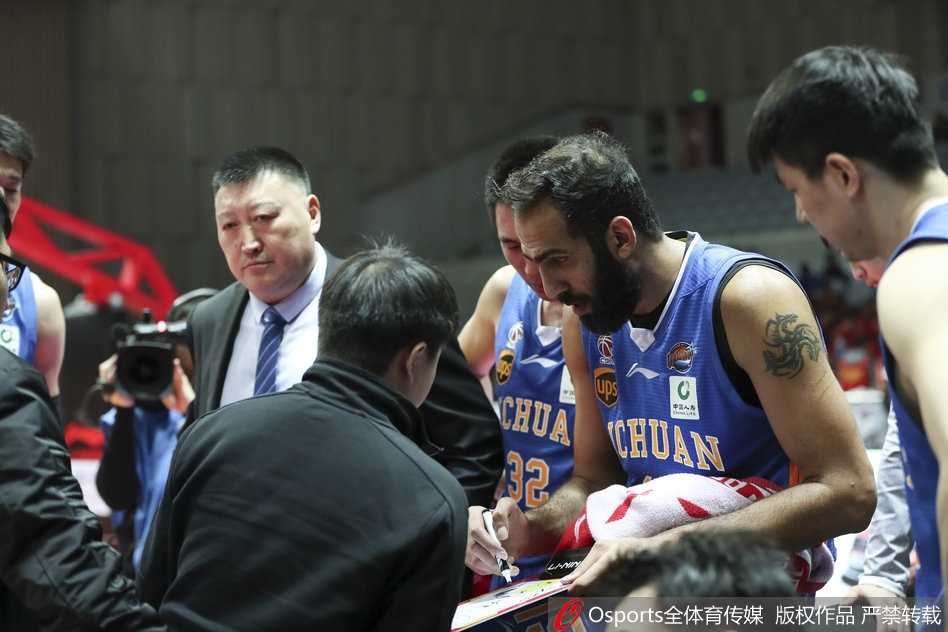 哈达迪在八一内线群中高高跃起，单臂将球劈入篮筐，身旁防守球员望球兴叹。