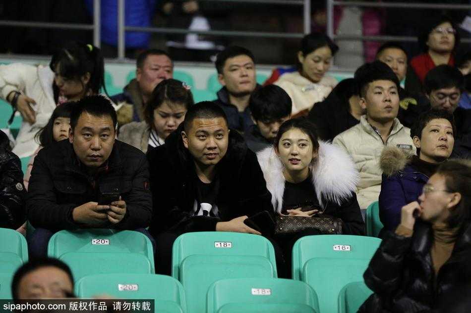 几位球迷在体育馆通道内合影留念，他们身上的貂绒大衣各不相同，但脸上都带着同样满足而自豪的微笑，为这场精彩的胜利留下永恒的瞬间。