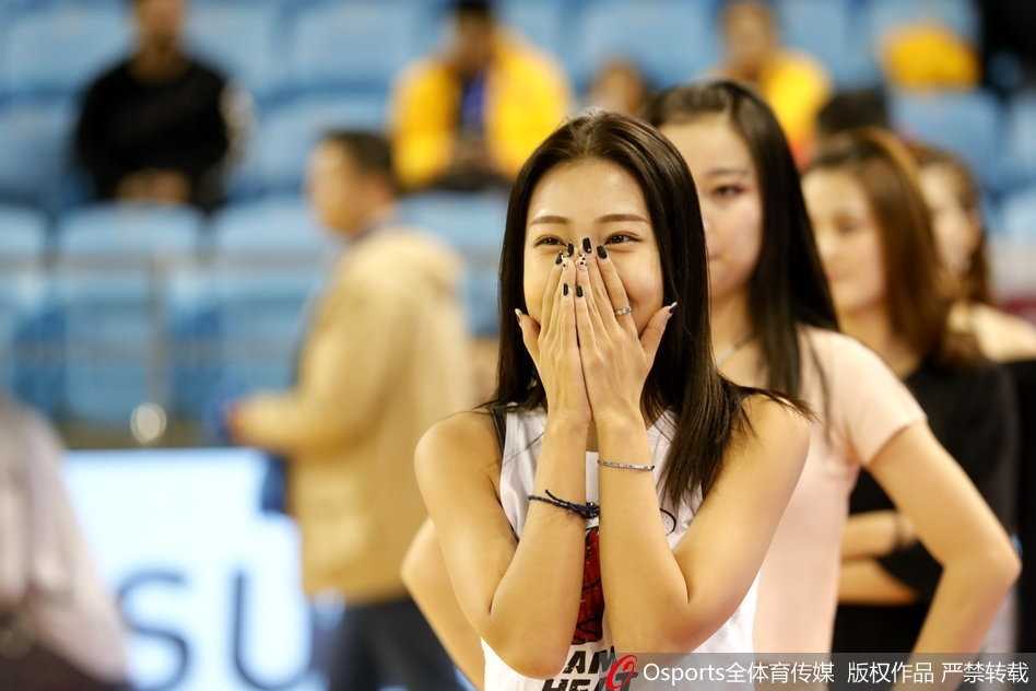 篮球宝贝们变换队形，在场地中央围成一圈，随着音乐节奏尽情舞动，红白相间的裙摆旋转开来，如同盛放在CBA赛场中央的朵朵火焰。