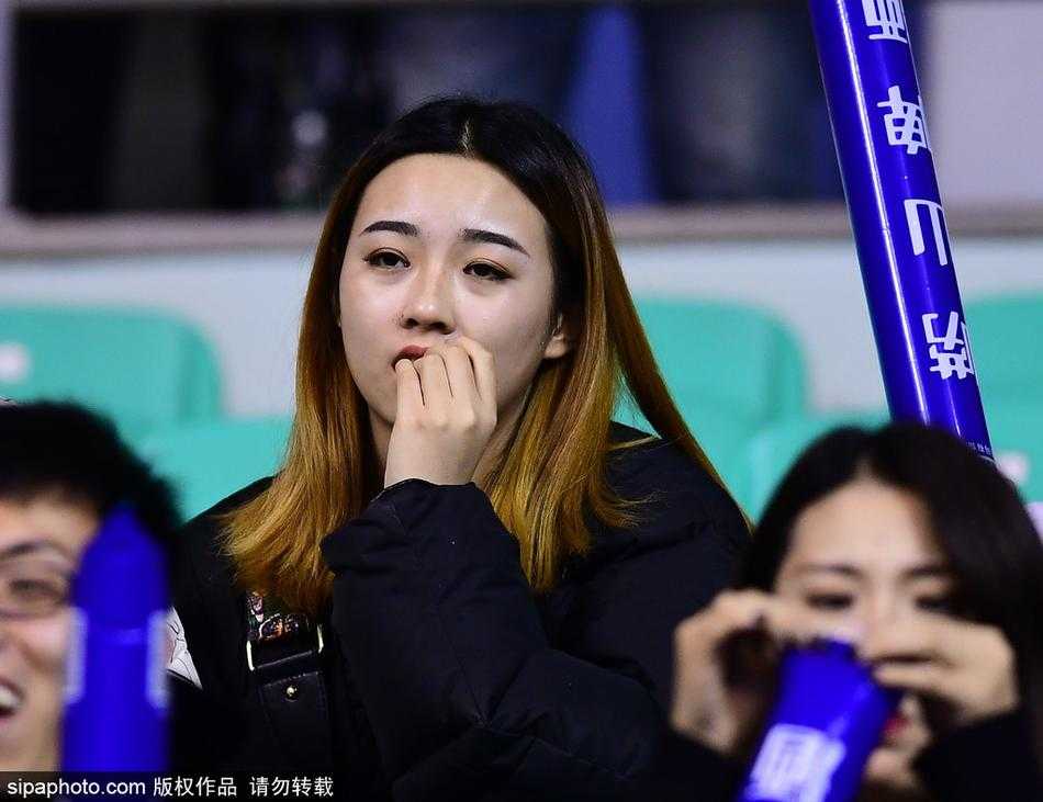 赛后，这位身穿白色毛衣的美女球迷面对镜头露出了甜美而略带羞涩的微笑。她手中挥舞着助威棒，身后的球场灯光映衬着她开心的面庞，这一幕为这个激烈的比赛夜晚画上了一个温暖而美好的句号。