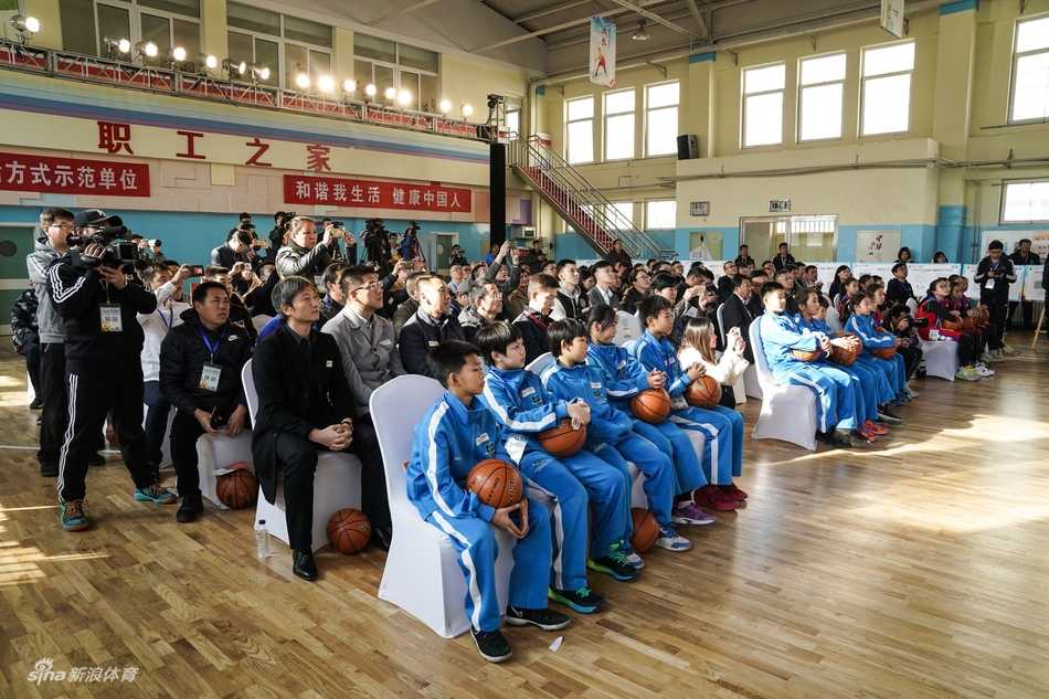 一群身穿红色球衣的小球员们在场边替补席上聚精会神地观看比赛，他们的眼神中充满了对球场的向往和团队荣誉感。