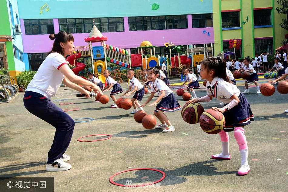 两名幼儿正面对面进行传接球练习，球在空中划出一道优美的弧线，对面的孩子张开双手准备稳稳接住，这一刻，信任与默契在他们之间无声传递。