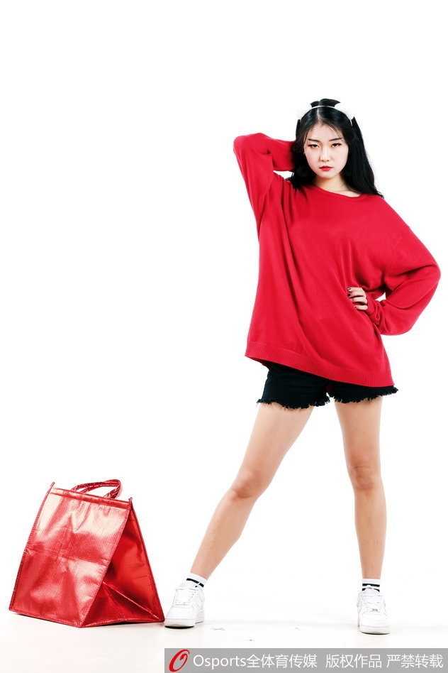 周晓彤扎起利落的马尾，露出甜美的微笑，活力四射的模样仿佛将中场休息的欢腾瞬间带到了静谧的摄影棚。