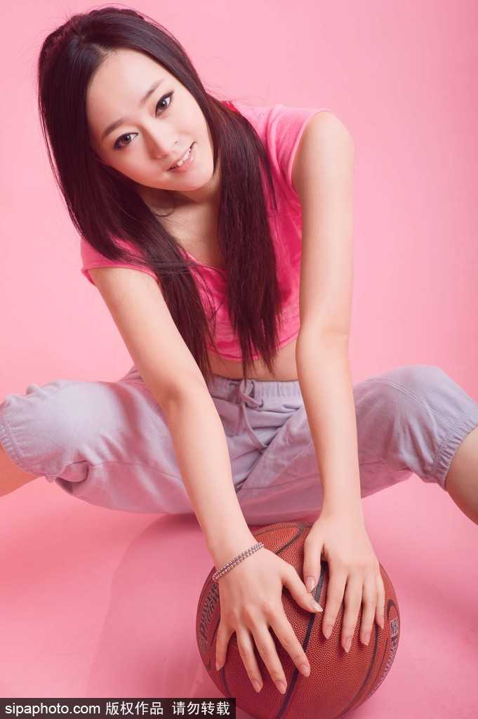 在午后斑驳的光影下，李昕瑶扎着清爽的马尾，眼神清澈地凝视着手中的篮球，仿佛在酝酿一个必胜的投篮策略。