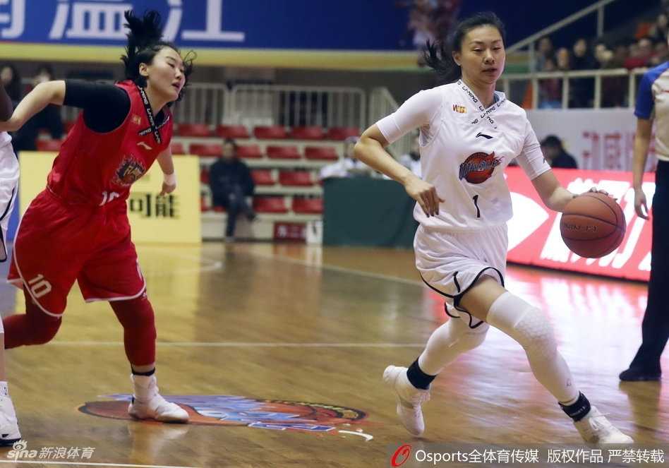 四川女篮队员龚芳竹突破分球，手臂舒展将球传给队友，脸上汗水飞扬彰显拼搏精神