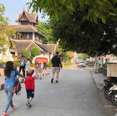 穿着深色T恤的姚明在泰国街头格外醒目，他双手悠闲地放在身后，正低头温柔地看着身边的妻女，即便只是一个背影，那巨人般的轮廓也让人一眼就能认出，画面充满了平凡的幸福感。