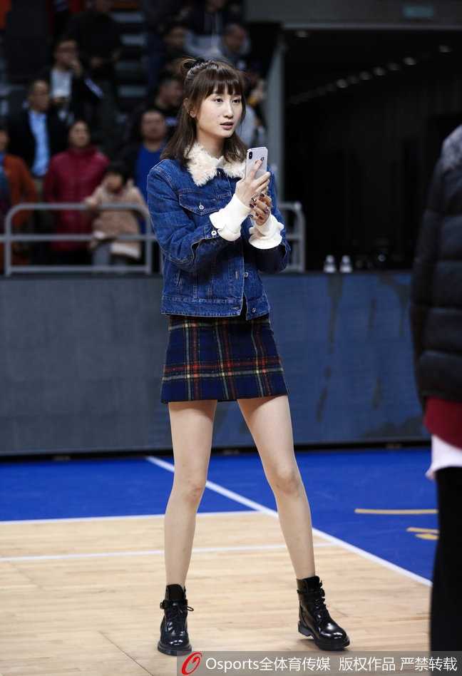 周鹏妻子刘美身着一袭时尚装扮，那修长身姿与温柔眼神，成为了东莞体育馆看台上最动人的风景。