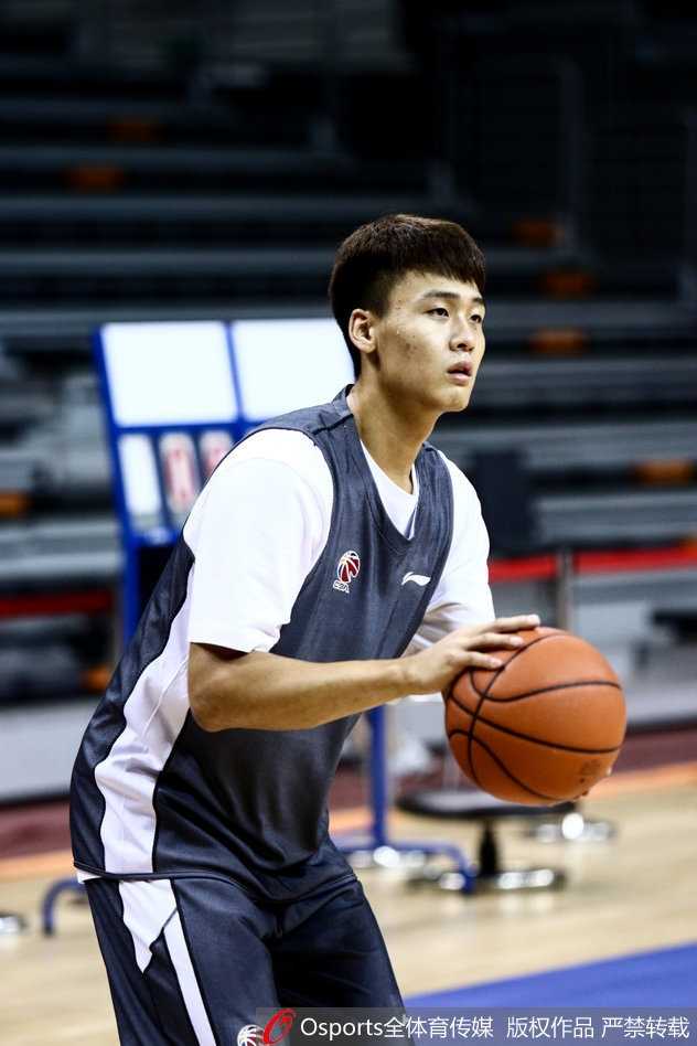 易建联在训练间隙露出难得的轻松笑容，与队友交谈，汗水浸透的训练服见证了他的刻苦与领袖风范