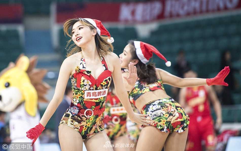 广州篮球宝贝们身穿圣诞红白短裙，在球场中央活力起舞，笑容灿烂。
