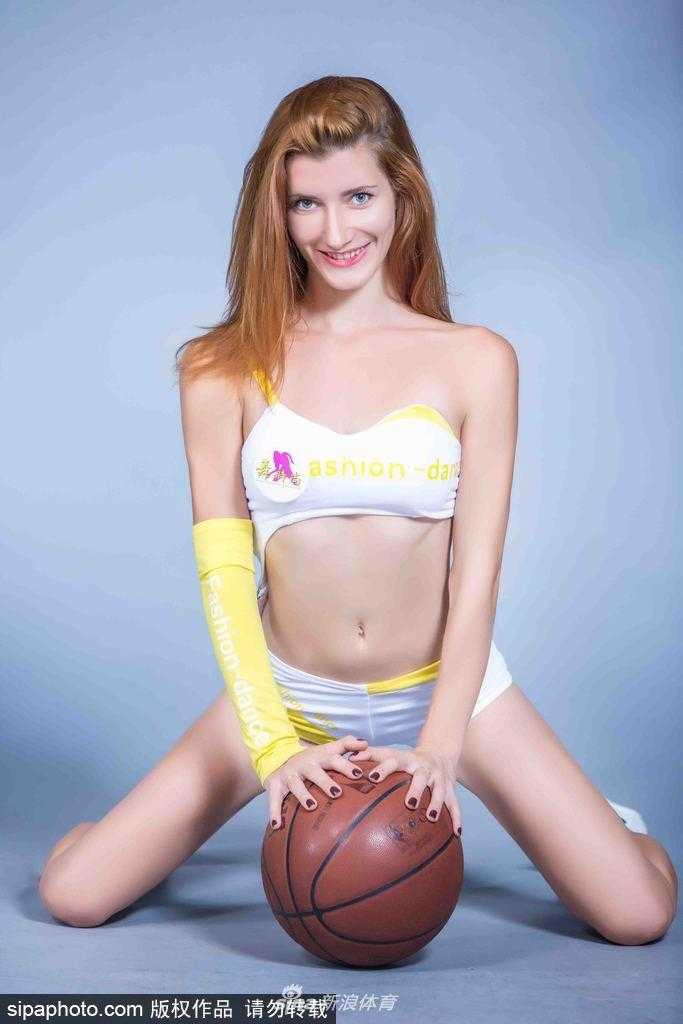 篮球宝贝身着亮丽表演服，肌肤胜雪，摆出妩媚动人的姿势，展现了力量与柔美的完美结合