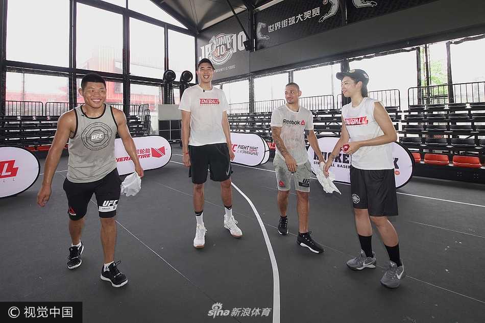 午后的粉丝见面会现场，霍洛威与李景亮坐在一起与热情的格斗粉丝交流，身后的背景板预示着UFC即将登陆上海的历史时刻，两人认真倾听的神情透露出对这场赛事的重视。