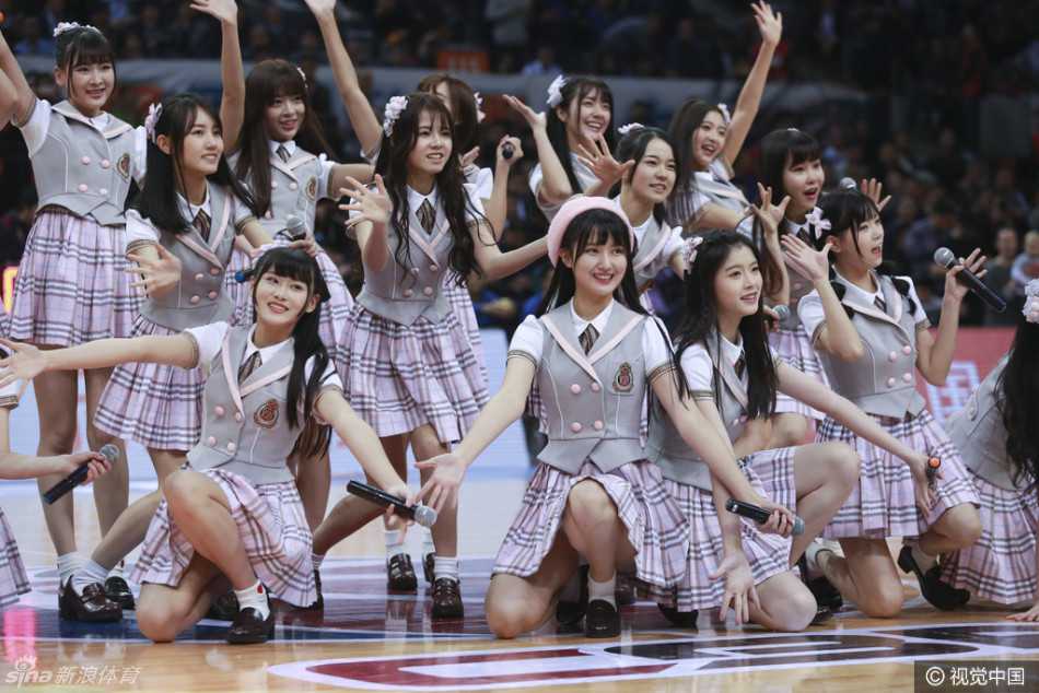 在人群的簇拥中，几位成员正低声交谈，侧脸在赛场灯光的勾勒下显得格外柔和，仿佛在分享着第一次现场看球的惊喜。