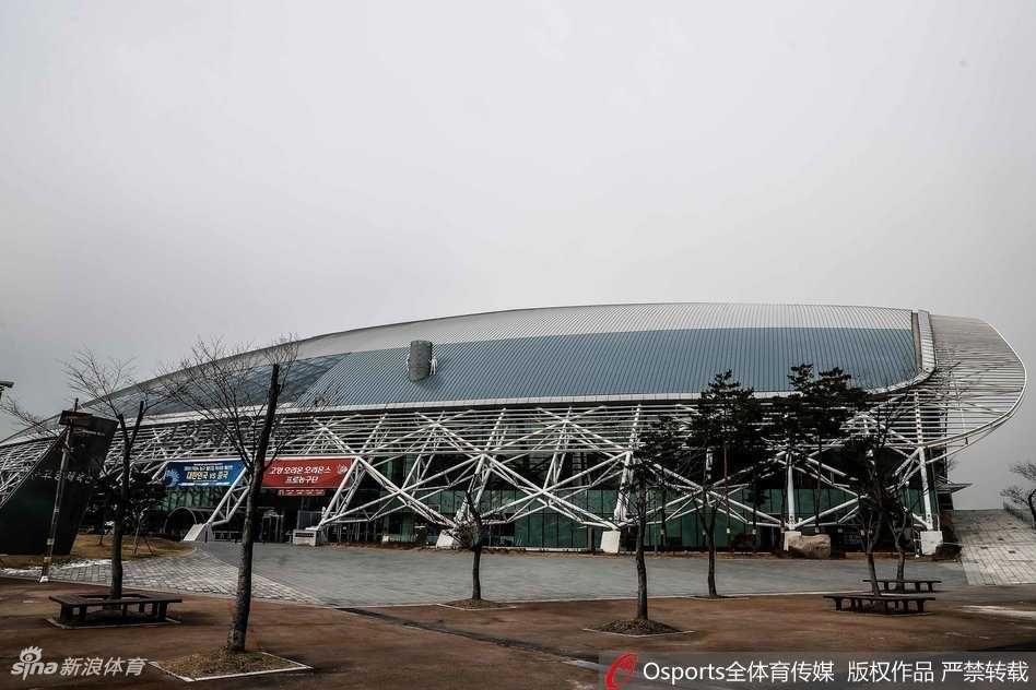 高阳体育馆内景，蓝色的座椅环绕全场，巨大的记分牌和FIBA旗帜静待中韩大战的哨声响起