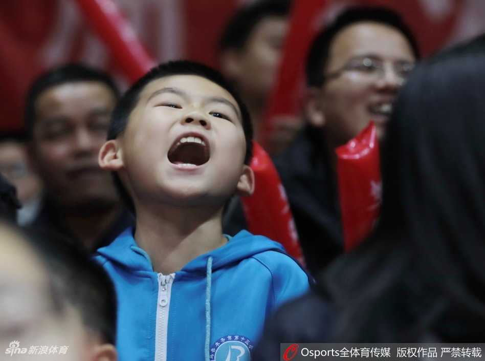 新疆男篮主场靓丽风景线 美女球迷激情助阵点燃红山 比赛暂停间隙,这位美女球迷对着镜头露出甜美的微笑,身后是同样沉浸在热烈气氛中的观众席。