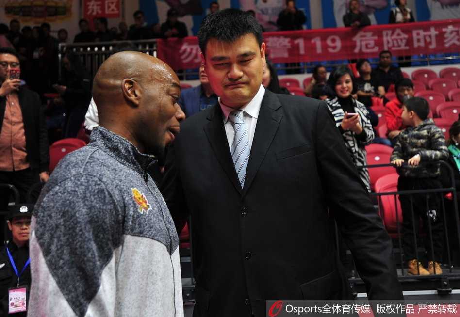 时光荏苒情谊未改:姚明与兰德里赛场叙旧 兰德里伸出手与姚明握手致意,姚明也伸手回应,两人目光交汇,一个握手传递的是多年未变的尊重与友谊,仿佛时间并未走远。