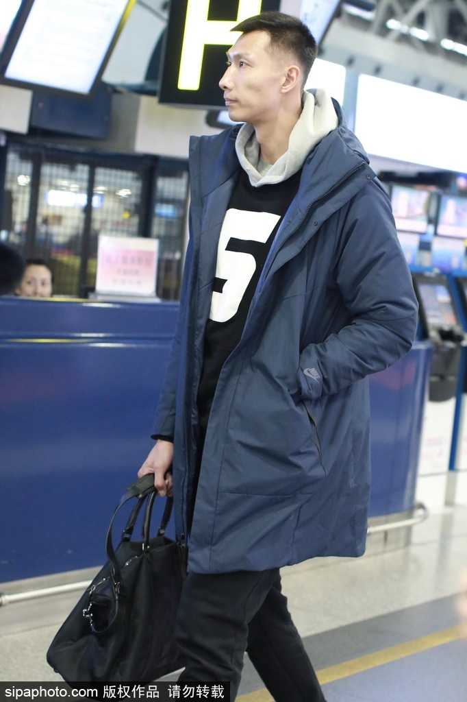 易建联潮装亮相机场背后的双面人生:从天才少年到篮球传奇 易建联在机场摆渡车上整理衣装,车窗外的光线映照出他专注的神情,时尚与运动在他身上得到了完美融合