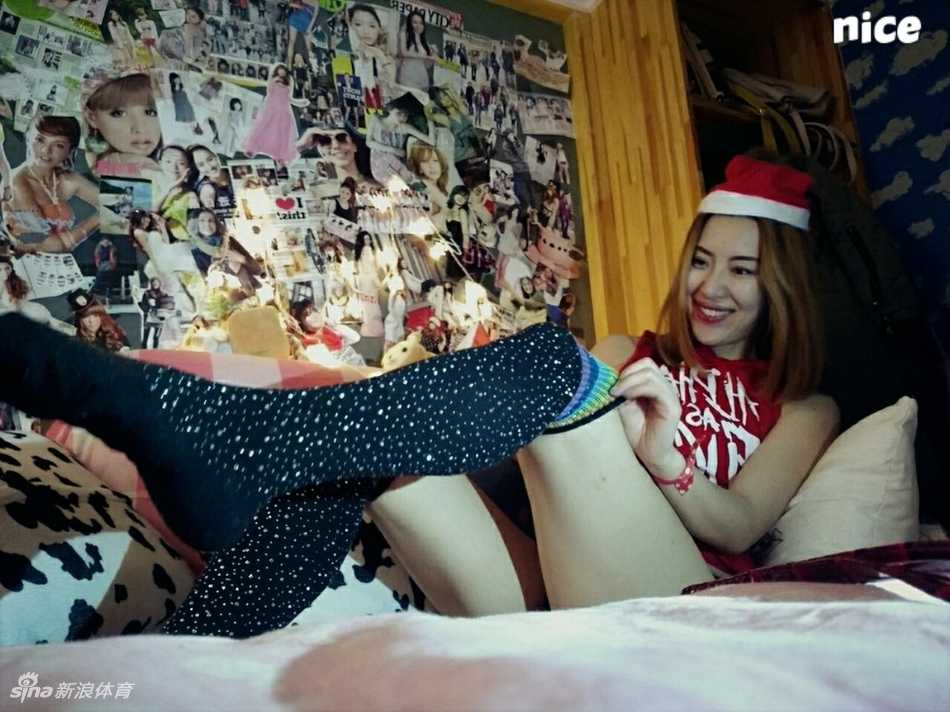 小雪侧身回眸，身后的圣诞彩灯虚化成斑斓的光斑，她深邃的眼神在暗调中透出一丝神秘的暧昧感