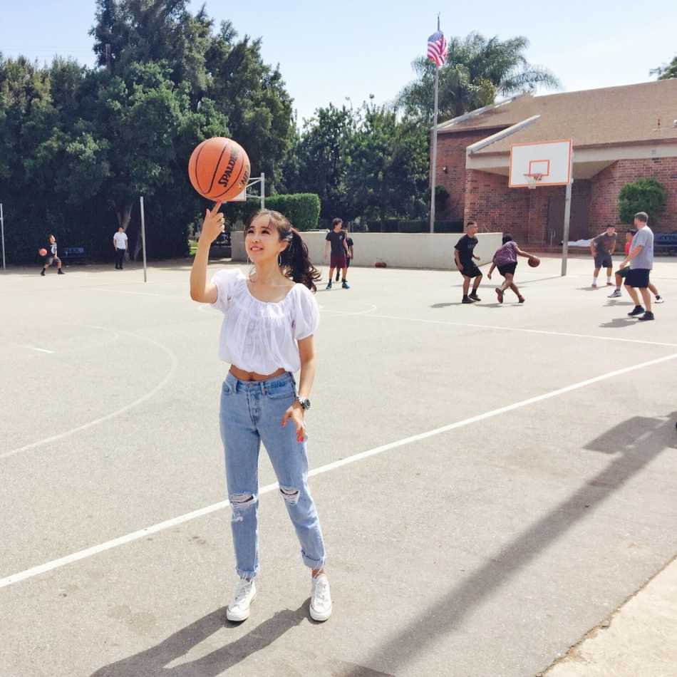 周玲安身穿深色修身连衣裙，侧身回眸，身姿曼妙，眼神坚定而深邃，背景虚化处理更突显其作为主持人的强大气场和优雅气质。