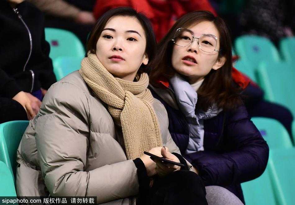 李晓旭的爱妻与好友在看台上合影留念，她们手中拿着辽宁男篮的助威围巾，笑容灿烂，记录下这个温馨而特别的比赛日。