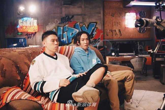 你的男孩TT身穿潮服，在涂鸦背景前活力四射，他脚上的Air Jordan 4 