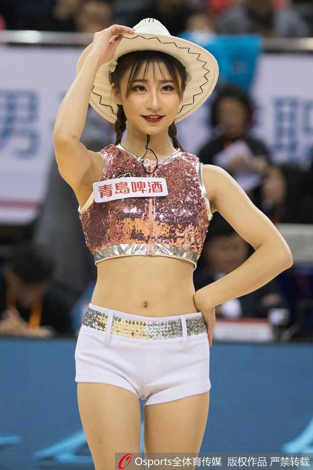 镜头特写一位领舞的篮球宝贝，她手持展开的彩扇，眼神专注而自信，扇面在她手中仿佛有了生命，随着音乐的节拍轻盈舞动。