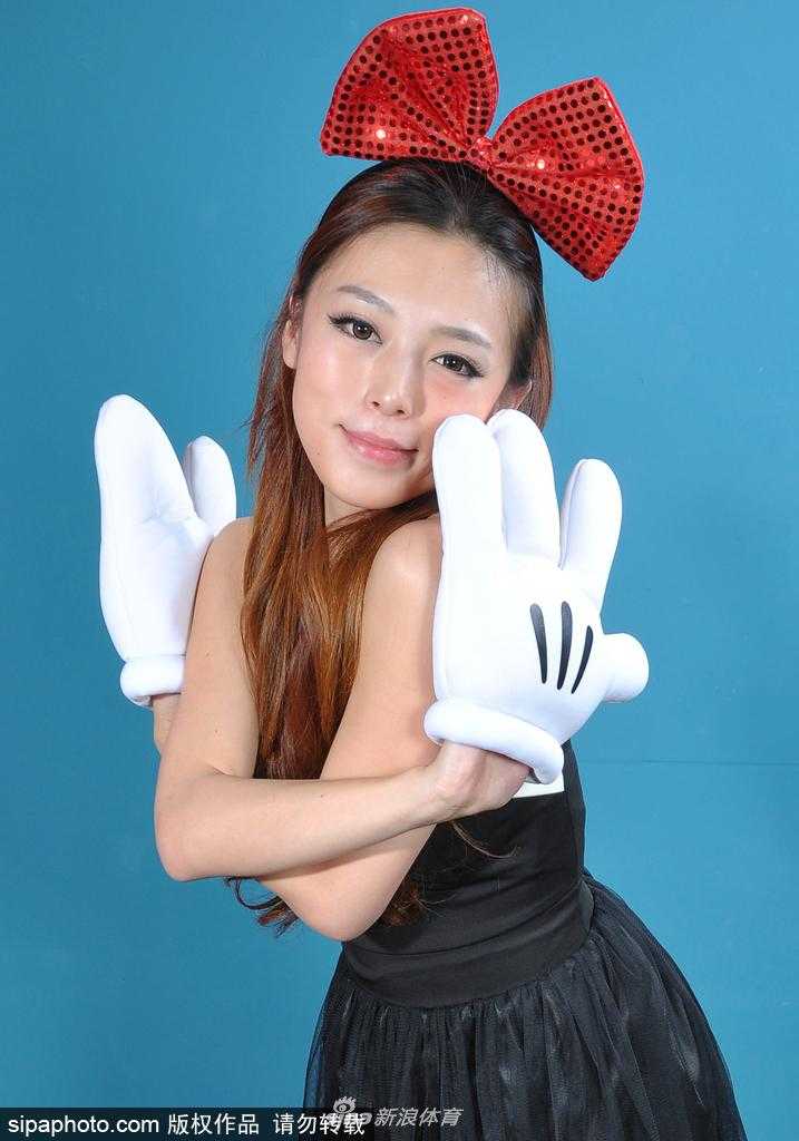 镜头拉近，这位戴着超大红色蝴蝶结的宝贝轻轻嘟起嘴巴，眼神清澈无邪，可爱的表情与赛场的激烈对抗形成了极具反差的“萌”感。