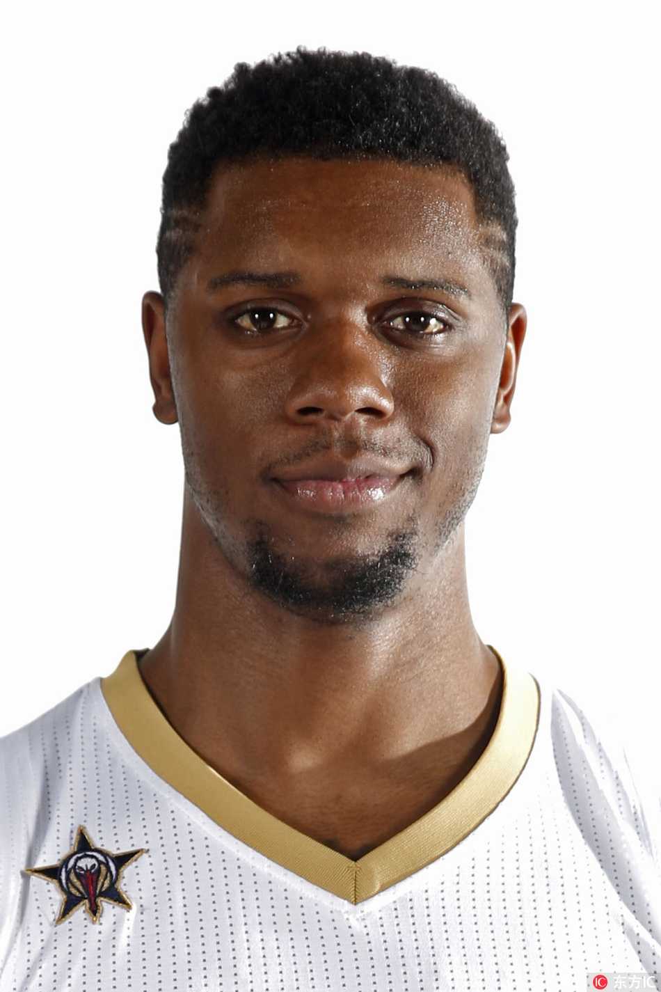 青岛队新闻发布会现场，琼斯展示新赛季球衣，身旁摆放着篮球，背景板上写满了青岛啤酒的标志，中西文化在这一刻交汇于篮球。