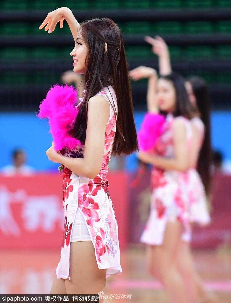 几位旗袍宝贝摆出结束造型，她们或坐或卧在球场地面上，旗袍的开衩设计巧妙地露出腿部线条，整体画面宛如一幅现代都市的仕女图。