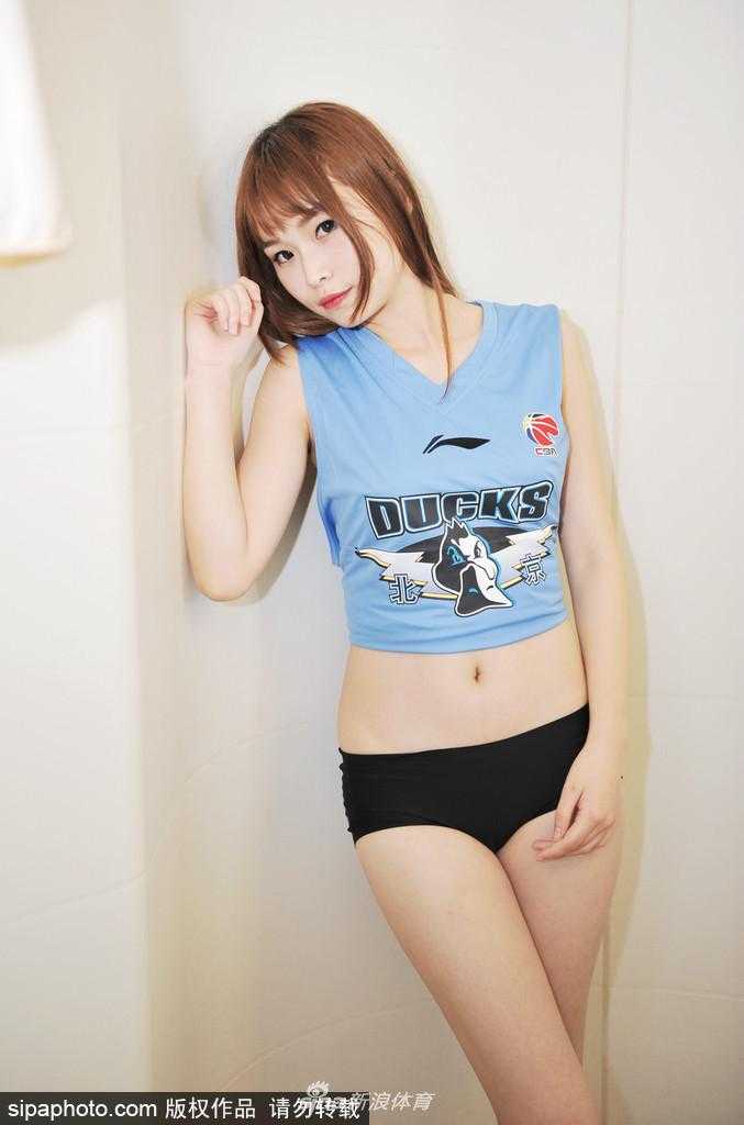 少女身着休闲装置身浴室，对着镜头露出甜美微笑，用青春活力支持北京首钢