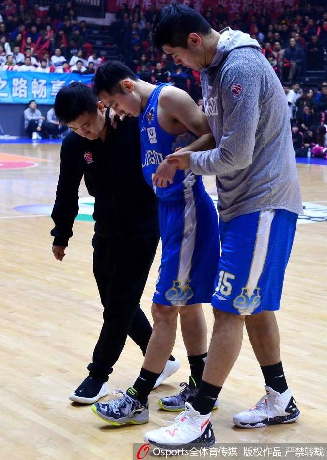 史鸿飞被搀扶着走向球员通道，背影显得无助而孤单，球衣上沾满的汗水见证了他在这场比赛中的拼搏与付出。