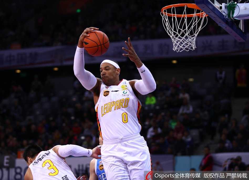 北京队小外援杰克逊在深圳队多人包夹下强行突破，他身体倾斜，努力寻找着传球或投篮的空间。