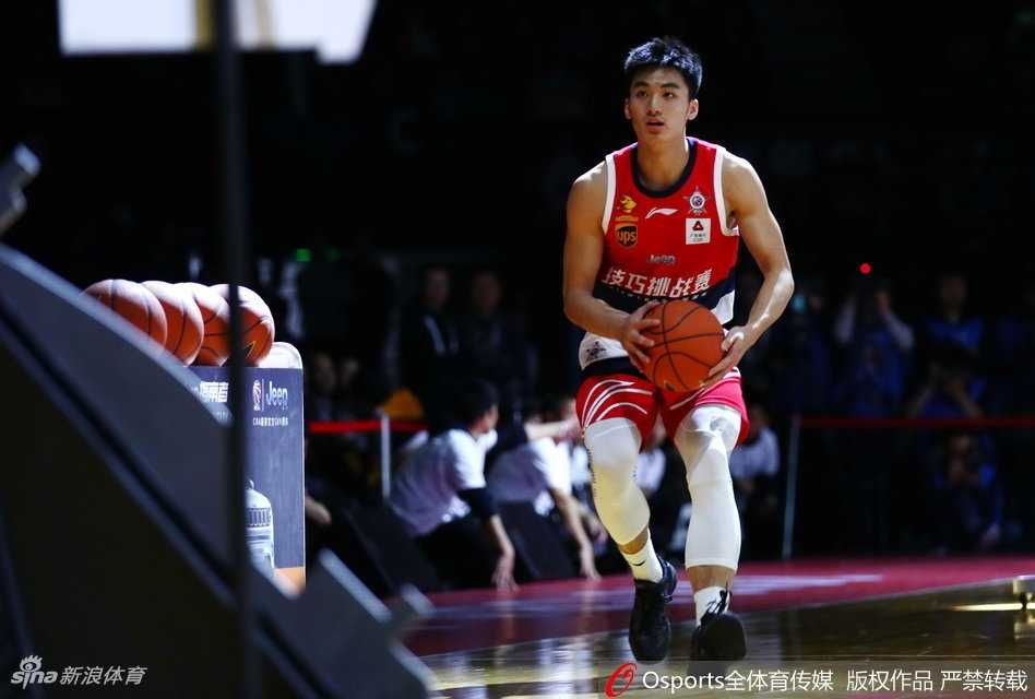 于德豪手持技巧挑战赛冠军奖杯，腼腆的笑容中透露出发自内心的喜悦，红色的冠军T恤映衬着现场璀璨的灯光。