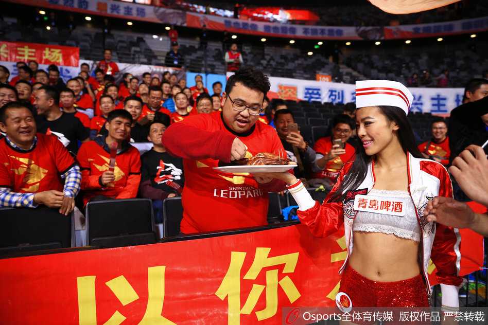 比赛进入白热化，北京队进攻受阻，场边的深圳队吉祥物和篮球宝贝们兴奋地举起手中的烤鸭道具，用夸张的表情为主队即将到来的胜利欢呼。